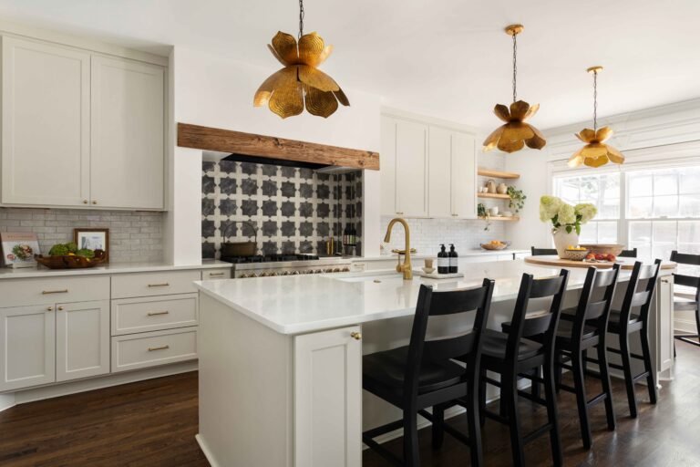Modern kitchen with white island black chairs flower shaped pendant lights and beige cabinetry remodel by AMI Build 768x512